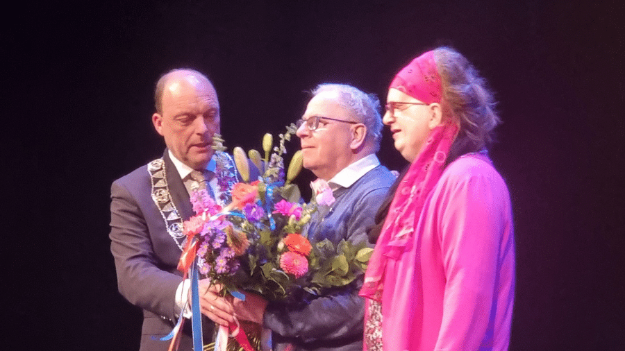 jan pijnaker ontvangt een lintje van burgemeester snijders van Zwolle en een grote bos bloemen