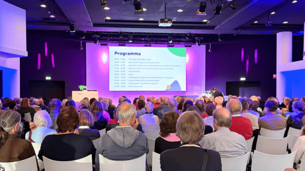 een volle zaal wacht geduldig tot de volgende presentatie begint