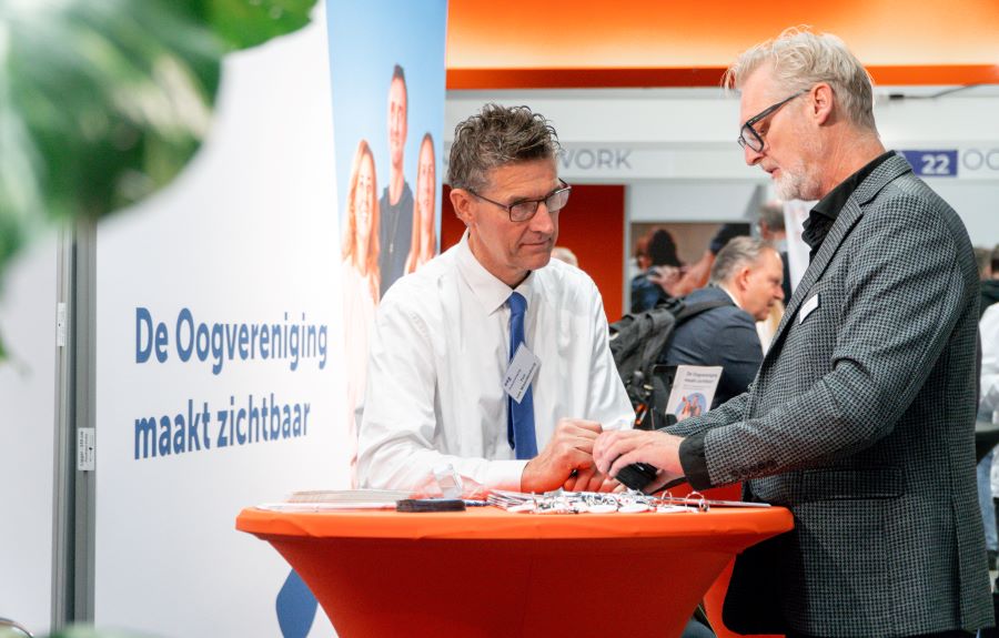 Ton Weerdenburg in gesprek in de stand van de Oogvereniging