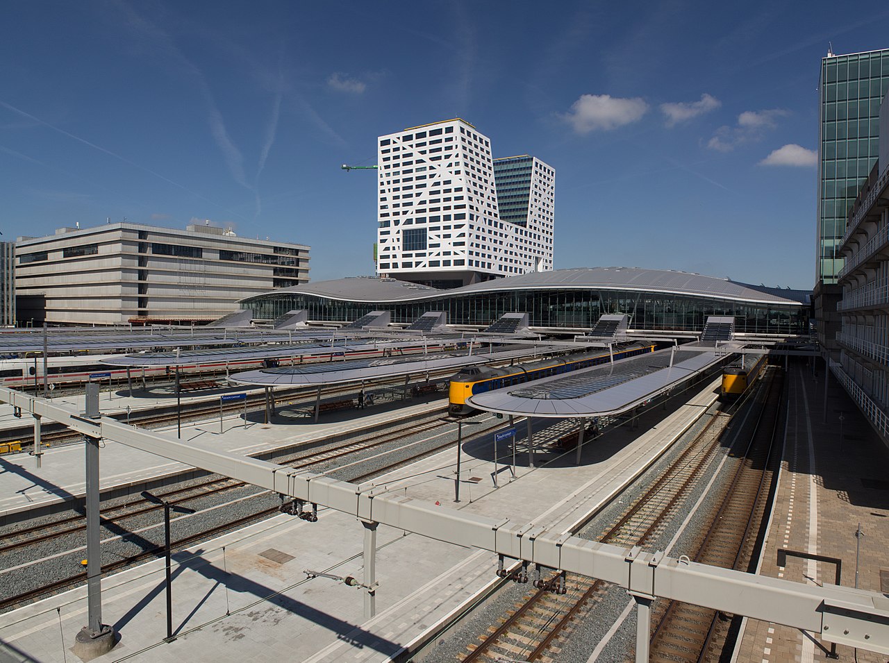 overzichtsfoto van utrecht centraal, er zijn verschillende treinsporente zien en een hoge kantoorgebouwen