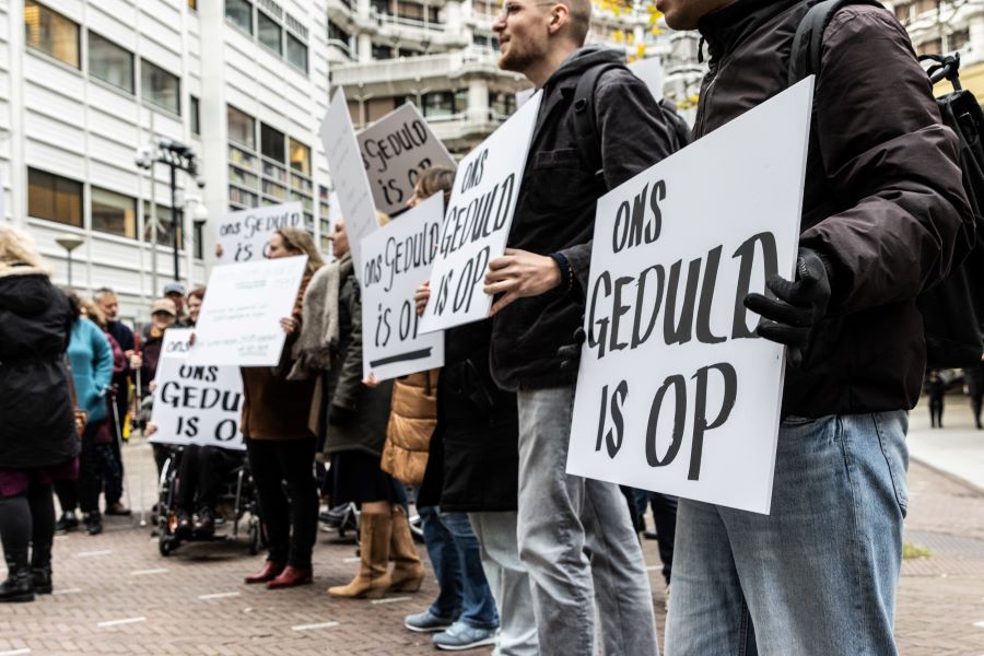 Demonstranten met borden met daarop de tekst 'Ons geduld is op'